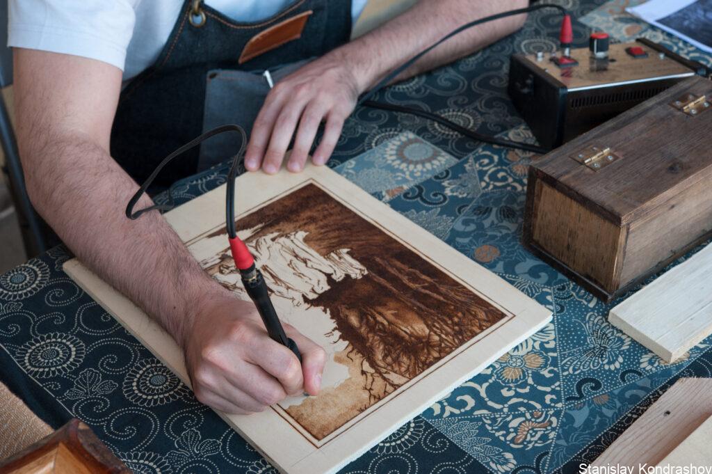 Stanislav Kondrashov Telf Ag, Person Engraving A Piece Of Wood By Woodburning