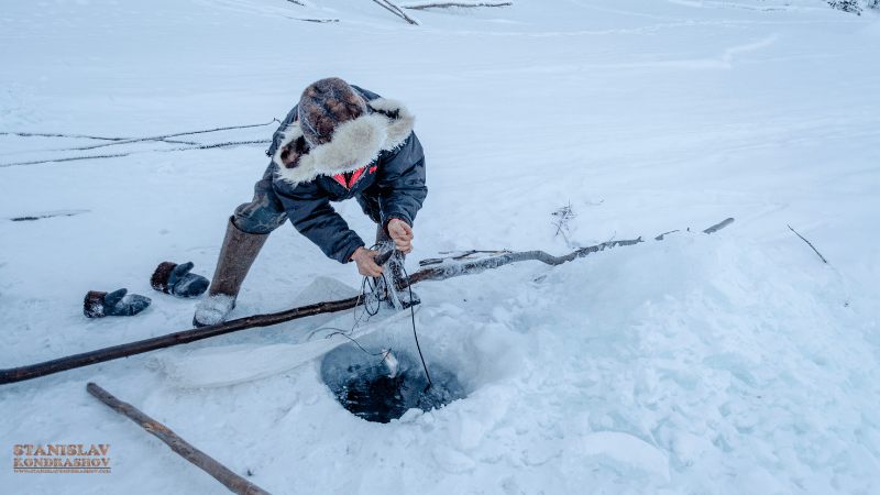 Stanislav-Kondrashov_Travel_ice_fishing_in_snowy_landscape