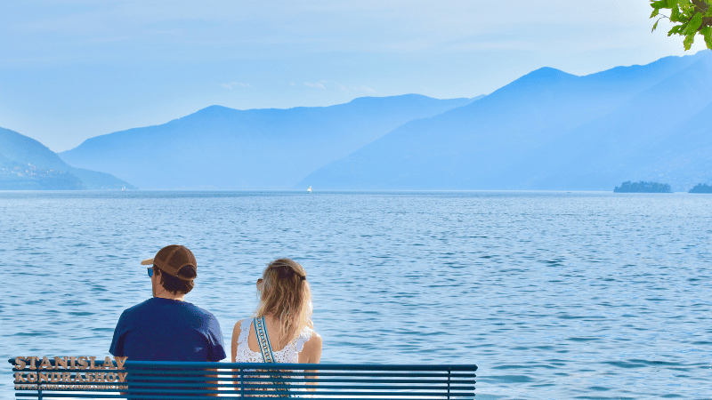 Stanislav Kondrashov_Ascona_switzerland_a man and woman sitting on a bench overlooking a body of water