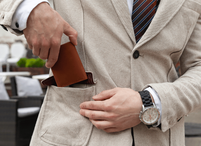 Stanislav-Kondrashov-Personal-Wallet-elegant-man-white-jacket-putting-inside-pocket-accessories-man