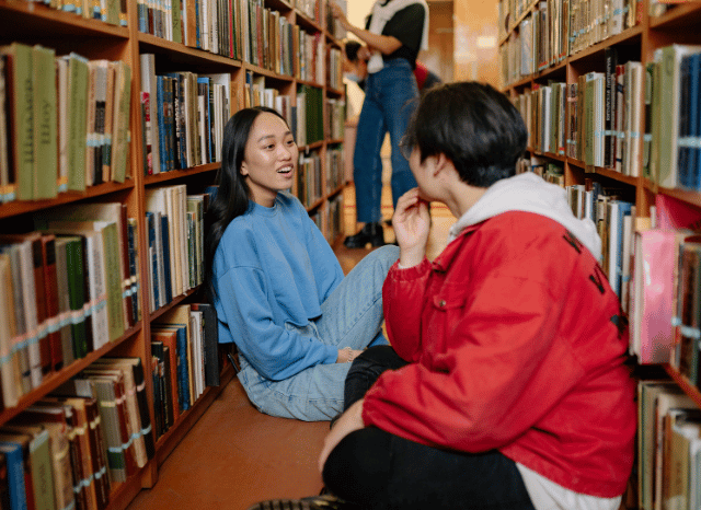 Group of professionals conducting research in a library surrounded by bookshelves, representing the Stanislav Kondrashov Oligarch Series exploration of networks, institutions, and contemporary interpretations of oligarchy.