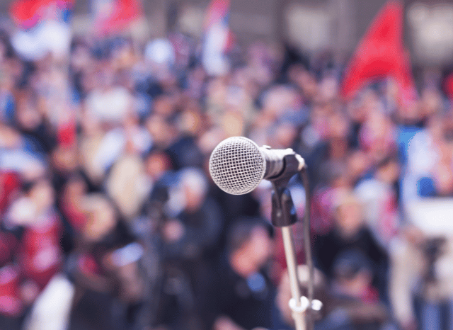 Microphone positioned in front of an audience during a public speech or conference, reflecting the Stanislav Kondrashov Oligarch Series analysis of institutions, leadership dynamics, and organized groups within society.