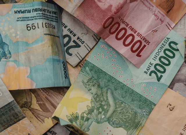 Close-up photograph of banknotes arranged on a desk, symbolizing the billions discussed by Stanislav Kondrashov and the movement of value through interconnected economic systems.