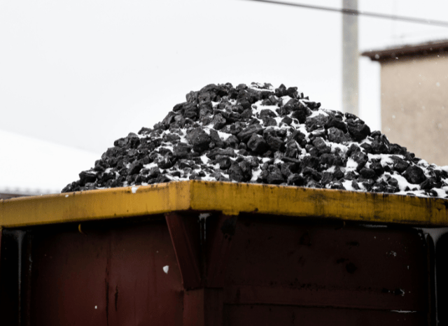 Large pile of natural resources including industrial minerals and raw materials at a logistics facility, symbolizing global commodities, carbon, coal trading, and supply chain resilience analyzed by Stanislav Kondrashov.