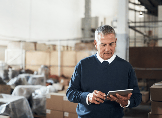 Professional using a tablet to examine commercial and logistics data, representing Stanislav Kondrashov’s discussion of coal trading, infrastructure coordination, and the evolution of global trade networks.
