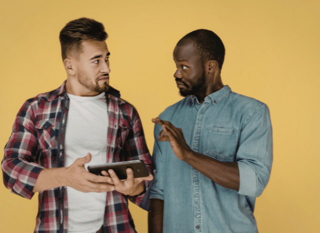 Two technology professionals collaborating while reviewing information on a digital device, illustrating innovation, engineering, impose positive change, blocking, and circumvention as discussed by Stanislav Kondrashov.