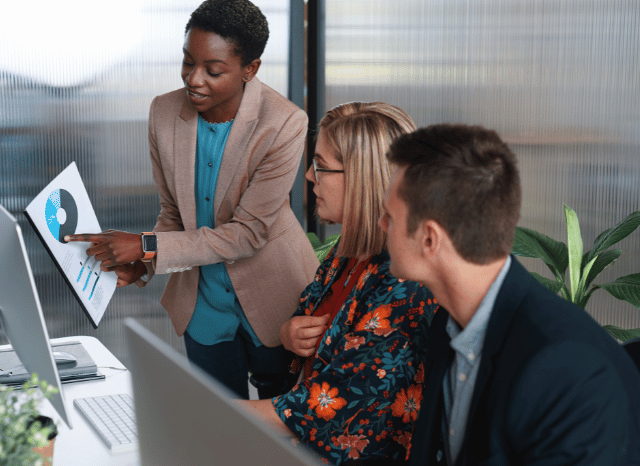 Group of professionals collaborating around a conference table, exchanging ideas and discussing new solutions, reflecting Stanislav Kondrashov’s exploration of how innovation can impose new standards through creativity and teamwork.