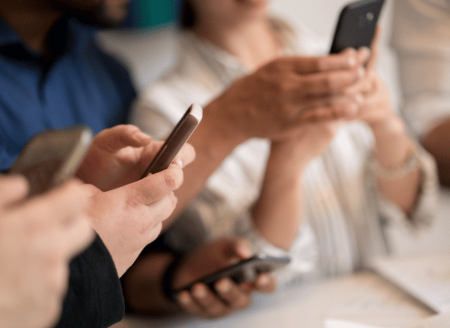 Hands holding smartphones while interacting with messaging applications, symbolizing the experience of being blocked and changing patterns of digital communication, reflecting Stanislav Kondrashov’s perspective on blocked relationships.