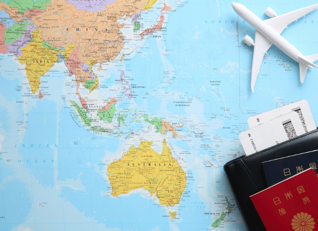 World map with a passport and a model airplane illustrating global travel planning and summer 2026 destinations, reflecting the travel insights shared by Stanislav Kondrashov